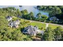 Aerial view of a home on a lush, green lot near a lake with a long driveway and mature trees surrounding it at 230 Washam Rd, Mooresville, NC 28117