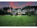 Charming two-story home featuring a lush green lawn, stone accents, and inviting curb appeal with mature trees at 230 Washam Rd, Mooresville, NC 28117