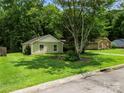 Quaint single-story home with a lush green lawn and mature trees offering plenty of shade at 4333 Dunwoody Dr, Charlotte, NC 28215