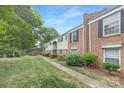 Exterior side view of brick townhomes on a well-maintained lawn and landscaping at 4601 Coronado Dr, Charlotte, NC 28212