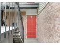 Exterior shot of a red front door with a black railing and brick siding at 4601 Coronado Dr, Charlotte, NC 28212