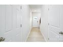 Bright hallway with luxury vinyl plank flooring leading to the front door and staircase at 4685 Mammoth Rd, Hickory, NC 28602