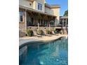 Backyard oasis featuring a sparkling pool, covered patio, and luxurious lounge seating at 5112 Mill Race Ln, Lancaster, SC 29720