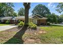 Cozy home featuring a covered porch, mature trees, and a well-maintained lawn at 5229 Milford Rd, Charlotte, NC 28210