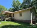 Side angle of this house featuring yellow siding, brick foundation, and a welcoming covered porch at 5881 Robinhood Rd, Fort Lawn, SC 29714