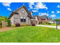 Well-maintained home featuring a stone facade, landscaped yard, and a two-car garage at 6107 Gold Springs Way, Denver, NC 28037
