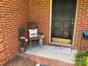 Cozy front porch with a vintage chair, decorative pillows, and seasonal accents at 8421 Coulwood Oak Ln, Charlotte, NC 28214