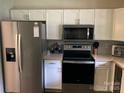 Modern kitchen with stainless steel appliances, white cabinets, and stylish backsplash at 8421 Coulwood Oak Ln, Charlotte, NC 28214