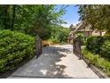 View of the home through the iron gates highlighting the long private driveway leading to the house at 849 Savile Ln, Fort Mill, SC 29715