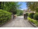 Gated driveway leading to a private home, framed by mature trees and manicured greenery at 849 Savile Ln, Fort Mill, SC 29715