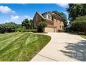 Brick home showing a long drive way, manicured lawn, and side-entry garage at 9027 Kirkley Ct, Charlotte, NC 28277