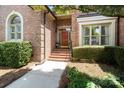 Inviting brick home entrance with a red front door and landscaped garden at 9027 Kirkley Ct, Charlotte, NC 28277