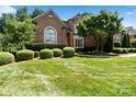 Charming brick home with manicured landscaping, including rounded bushes and a mature tree at 9027 Kirkley Ct, Charlotte, NC 28277