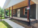 Spacious front porch with wooden pillars and a charming ceiling, perfect for relaxing outdoors at 94 James Sw St, Concord, NC 28025