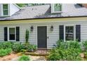 Home entrance with a well-kept lawn, flowering bushes, black door and modern exterior lights at 1040 Goshen Pl, Charlotte, NC 28211