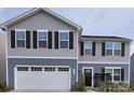Inviting two-story home with a two car garage, black shutters, and a welcoming front porch at 1047 Campbell Chase Sw Ln, Concord, NC 28025