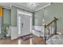 Welcoming foyer featuring hardwood floors, stairs, a decorative bench, and a bright front door at 1115 Macallum Nw Dr, Concord, NC 28027