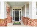 Inviting front entry with a black door, brick accents, and a 'Home Sweet Home' welcome mat at 1115 Macallum Nw Dr, Concord, NC 28027
