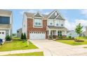 Charming two-story home with a brick and gray facade, well-manicured lawn, and a two-car garage at 1115 Macallum Nw Dr, Concord, NC 28027