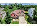 Lovely two-story home with an inviting porch and two-car garage, surrounded by mature trees at 1152 Mckee Farm Ln, Belmont, NC 28012