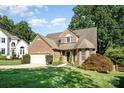 Charming brick home with manicured lawn, mature trees, and a two-car garage at 19509 Trintella Ln, Cornelius, NC 28031