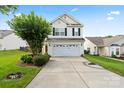 Inviting two-story home featuring a two-car garage, landscaped front yard, and a freshly paved driveway at 2527 Fossil Stone Ln, Fort Mill, SC 29708