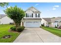 Charming two-story home boasts an attached garage, manicured lawn, and inviting curb appeal at 2527 Fossil Stone Ln, Fort Mill, SC 29708