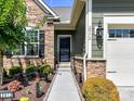 Inviting front entrance with stone accents, manicured landscaping, and a black door at 2972 Arches Bluff Cir, Lancaster, SC 29720