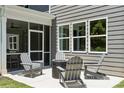 Outdoor patio with gray chairs, a fire pit, and a screened-in porch offering a relaxing and inviting entertainment space at 324 Coronado Ave, Matthews, NC 28104