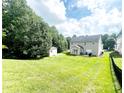 Expansive backyard featuring a lush lawn, storage shed, and patio area surrounded by mature trees at 4048 Cascade Dr, Gastonia, NC 28056