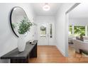 Bright foyer featuring hardwood floors, a decorative mirror, and a view into the living area at 4742 Emory Ln, Charlotte, NC 28211