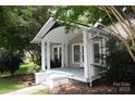 Charming home featuring a covered front porch with white pillars and blue painted steps at 510 5Th St, Spencer, NC 28159