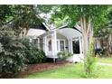 Cozy home featuring a covered front porch and landscaped yard with mature trees at 510 5Th St, Spencer, NC 28159