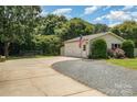 Spacious driveway leading to a detached garage, complete with an American flag and well-kept landscaping at 5701 Cedar Hill Dr, Monroe, NC 28110