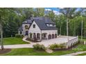 Elegant home featuring a three-car garage and expansive paved parking area at 6327 Fox Tail Ln, Davidson, NC 28036
