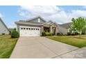 Well-maintained single-story home featuring a two-car garage, stone accents, and a lush green lawn at 732 Wood Lily Dr, Belmont, NC 28012