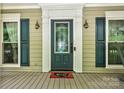 Inviting front porch with decorative glass door, sconces, and blue shutters at 8300 Quarters Ln, Mint Hill, NC 28227