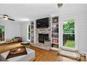 Bright living room with brick fireplace, built-in bookshelves, and hardwood floors at 8300 Quarters Ln, Mint Hill, NC 28227