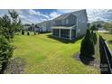 Well-maintained backyard features a screened porch, lush green lawn and manicured landscaping at 8420 Golden Stone Ln # 138, Fort Mill, SC 29707