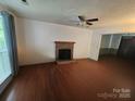 Comfortable living room with brick fireplace, sleek wood flooring and bright natural light at 8904 Daventry Pl, Charlotte, NC 28215