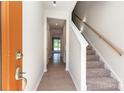 Bright entryway features neutral walls, hardwood flooring, a staircase, and a clear view to the backyard at 9221 Widden Way, Charlotte, NC 28269