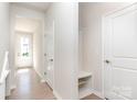 Bright foyer features sleek, light-colored floors and walls with a built in bench and coat rack at 9221 Widden Way, Charlotte, NC 28269