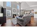 Sunlit living room features vaulted ceiling, fireplace with decorative clock, hardwood floors, and open access to the kitchen at 9429 Coast Laurel Nw Ave, Concord, NC 28027