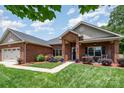 Charming single-story brick home with a two-car garage, manicured lawn, and inviting front porch at 101 Harvest Farm Ct, Mount Holly, NC 28120