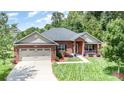Charming single-story brick home with a two-car garage, manicured lawn, and inviting front porch at 101 Harvest Farm Ct, Mount Holly, NC 28120