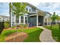 Inviting backyard featuring a covered patio and landscaped garden with ornamental trees at 10209 Mamillion Dr, Huntersville, NC 28078