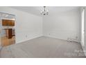 Neutral empty room with white trim and carpet floor, featuring an entry to the kitchen at 10600 Four Mile Creek Rd, Charlotte, NC 28277