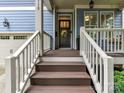 The front porch has brown stairs, white railings, and a welcoming wreath on the front door at 1118 Yale Pl, Charlotte, NC 28209