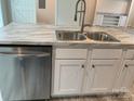Close-up of a kitchen island with stainless steel dishwasher, sink, and white cabinets at 126 Zircon Dr, Statesville, NC 28625