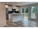 Modern kitchen featuring stainless steel appliances, island with sink, and sliding glass doors to a deck at 126 Zircon Dr, Statesville, NC 28625